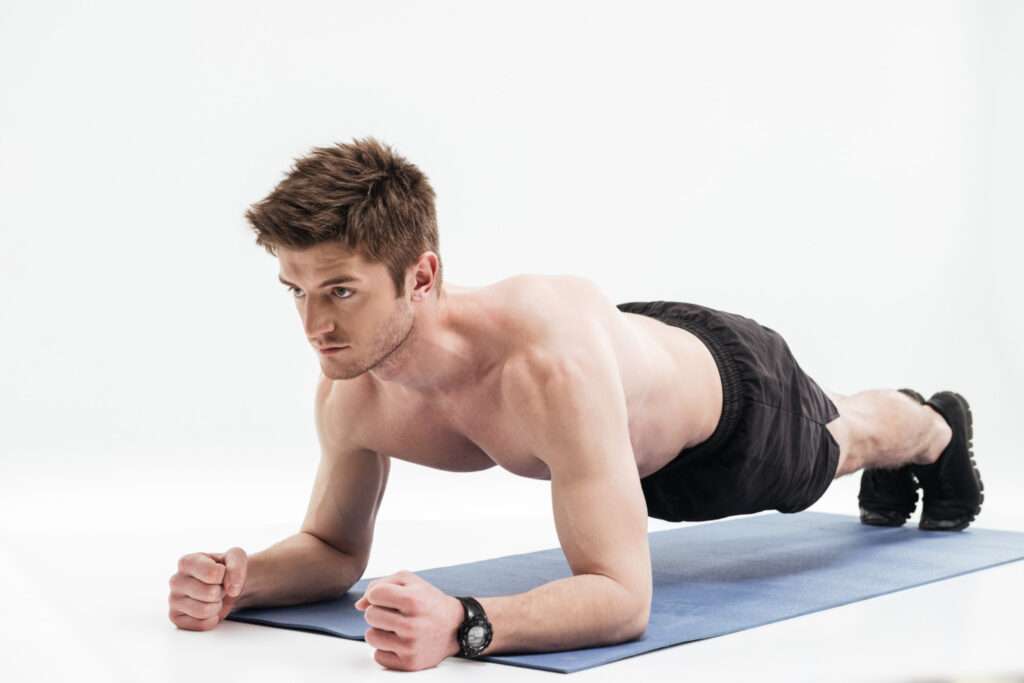 young sportsman doing plank exercise fitness mat